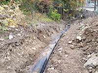 Open ditch with water main laid the length of the ditch.